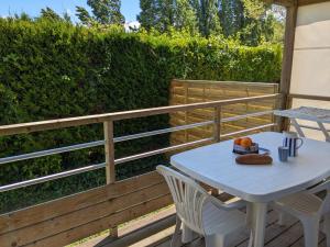 a white table and chairs on a wooden deck at Camping Les Payolles in Saint-Georges-dʼOléron
