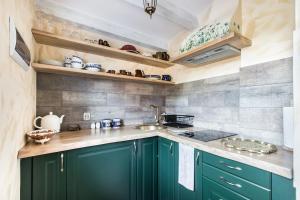 a kitchen with green cabinets and a sink at Norka Niziołka na Starej Pompce in Czeremcha