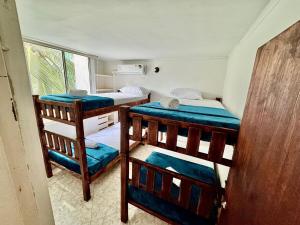 a room with two bunk beds and a window at Tu Refugio Tropical Cerca al Mar in Santa Marta +29 photos
