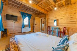 a bedroom with a large bed in a wooden room at Casa WEZLY in Măgura