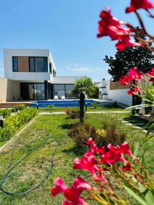 une maison avec des fleurs rouges devant elle dans l'établissement Mardakan Family Villa, à Mardakan