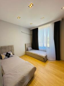 une chambre avec deux lits et une grande fenêtre dans l'établissement Mardakan Family Villa, à Mardakan