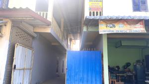 un edificio con una puerta azul frente a un edificio en Manyvanh Guesthouse, en Luang Prabang