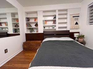 a bedroom with a large bed with white shelves at Peter's Place - Spacious 2Bed & Bath Suite in Surrey