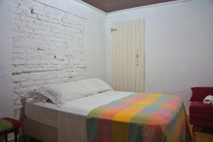 a bedroom with a bed with a colorful blanket at Solar dos Ventos BANANEIRAS in Bananeiras