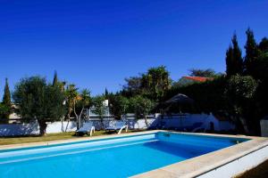 einen Pool mit zwei Stühlen und ein Haus in der Unterkunft Vivienda Rural Atlántico Sur & Family in Conil de la Frontera