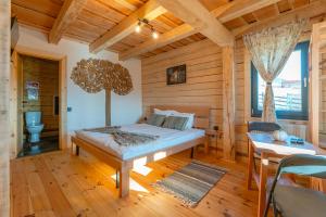 a bedroom with a bed in a room with wooden walls at Casa WEZLY 2 in Măgura