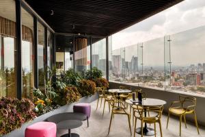 a restaurant with tables and chairs and windows at Resort Home with Extraordinary City View in Mexico City