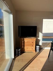 居让梅斯特拉Maison familiale piscine 3 chambres Gujan-Mestras !的客厅的木制梳妆台上配有平面电视