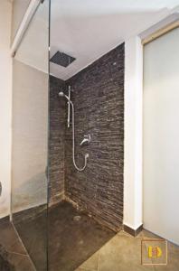 een douche in een kamer met een bakstenen muur bij Dammusi Ambra in Pantelleria