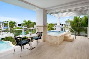 un balcone con tavolo, sedie e piscina di Dreams Cap Cana Resort & Spa a Punta Cana Altre 9 foto