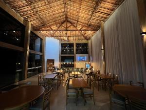 a dining room with tables and chairs and windows at Pousada e Restaurante Terra Rossa in São José do Rio Pardo
