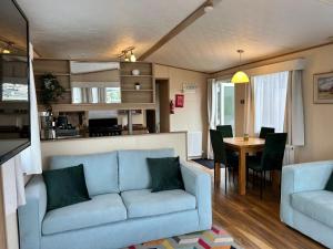 a living room with a blue couch and a table at Holiday Home with Private Hot Tub in Bembridge