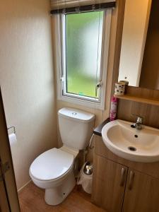 a small bathroom with a toilet and a sink at Holiday Home with Private Hot Tub in Bembridge
