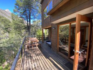 una terrazza in legno con tavolo e panca di Cabañas Manquecura a Las Trancas