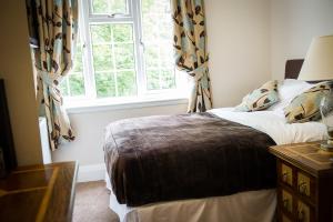 a bedroom with a bed in front of a window at Claverton Hotel in Battle