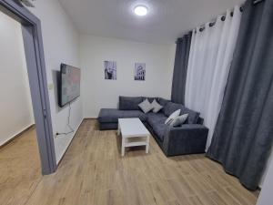 安曼Sama Dier Ghbar 3的客厅里有一张沙发和一张桌子。