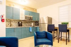 a kitchen with blue chairs and a stainless steel refrigerator at Charming & Family-Friendly Boqueron Village Condos! in Boqueron