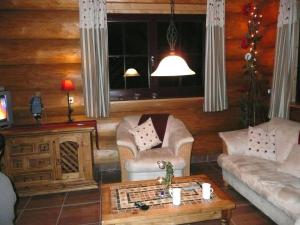una sala de estar con un sofá y una mesa en Cozy wooden house in Waltershausen near the forest, en Emsetal
