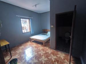 Una pequeña habitación con una cama y una ventana. en Manyvanh Guesthouse, en Luang Prabang 4 fotos más