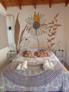1 dormitorio con 1 cama con un mural de girasoles en la pared en Cabaña Los Radales, en San Martín de los Andes
