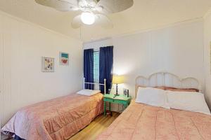 a bedroom with two beds and a lamp and a table at Seaspray 360 in Atlantic Beach +25 photos