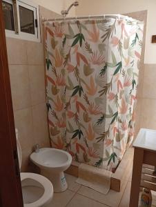 y baño con cortina de ducha y aseo. en Cabaña Los Radales, en San Martín de los Andes