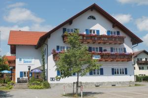 a large white building with a balcony at Gasthof Janser in Altenstadt