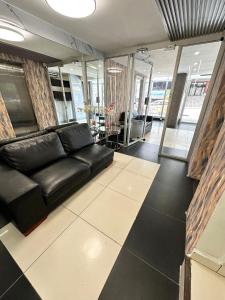 a living room with a black leather couch in a room at HOTEL 2 Mares PANAMA in Panama City
