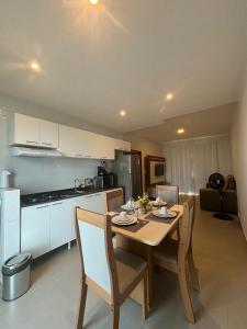 a kitchen with a table and chairs in a room at Condomínio Boas Vistas in Aracati +3 photos
