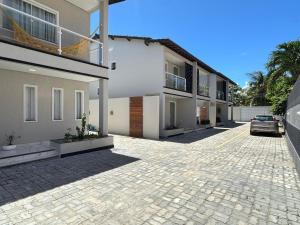 ein Haus mit einem in einer Einfahrt geparkten Auto in der Unterkunft Casa Brisa do Mar in Lauro de Freitas