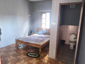 Un dormitorio pequeño con una cama y un baño. en Manyvanh Guesthouse, en Luang Prabang