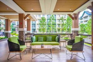 une terrasse avec un canapé vert et 2 chaises dans l'établissement The Zen Den, Pine Suites Tagaytay, à Tagaytay