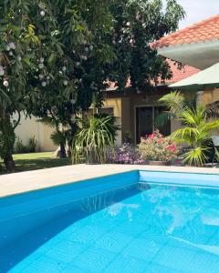 a blue swimming pool in front of a house at TIKA Casa Jardín & Suites - Suite 1 in Machala