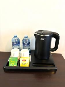 a tray with a coffee pot and bottles of water at Chambre Lucas Salle de bain Privative in Paris