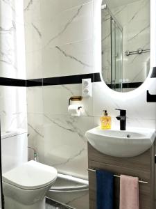 a bathroom with a sink and a toilet and a mirror at Chambre Lucas Salle de bain Privative in Paris +42 photos