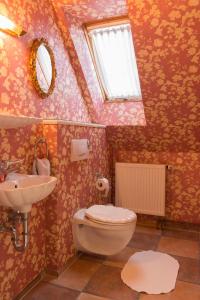 a bathroom with a toilet and a sink and a window at Ferienwohnung Burg Eltz in Treis-Karden