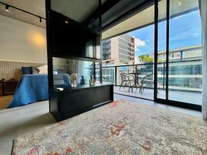 a bedroom with a bed and a television and a balcony at VN Millennium Faria Lima in São Paulo +58 photos