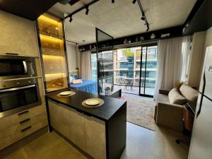 a kitchen with a counter and a living room at VN Millennium Faria Lima in São Paulo
