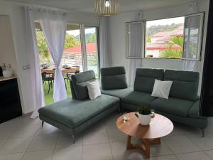 a living room with a couch and chairs and a table at Nomade Evasion - Escale Paisible in Petit-Bourg