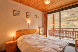 Un dormitorio con una cama y una ventana grande en Eperon - Les 2 Alpes, en Les Deux Alpes