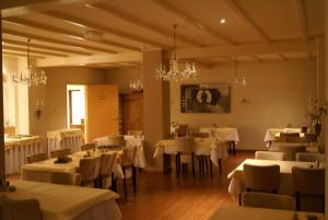 a dining room with white tables and chairs and chandeliers at Hotel Bemelmans in Schin op Geul