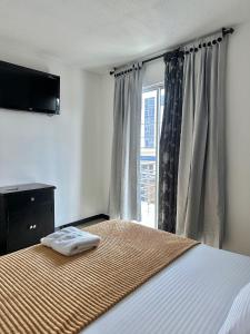 布卡拉曼加Hotel Palmeras De Mariana的一间卧室设有一张带电视和窗户的床。