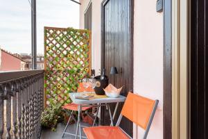 a table and chairs on a balcony with a fence at Benaco Apartment - 98mq Comfort & Style -Milano- Fondazione Prada in Milan