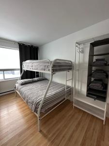 een slaapkamer met twee stapelbedden en een houten vloer bij 881 L'APPARTEMENT FAMILIAL "Central" in Québec
