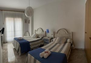 una camera da letto con due letti con asciugamani sopra di Quererte a Teruel