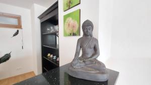 une statue assise sur une table dans une pièce dans l'établissement Apartment Orange, à Karlovy Vary