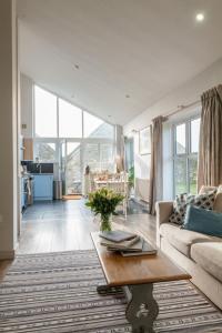 un soggiorno con un divano e un tavolo di Blueberry Barn, light and airy barn conversion near Bruton a Bruton