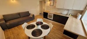 a kitchen and a living room with a table and chairs at Apartament Przy Bocznej in Kowary