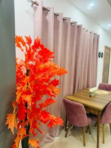 a table and a tree with red and orange leaves at Marie in Grand-Bassam